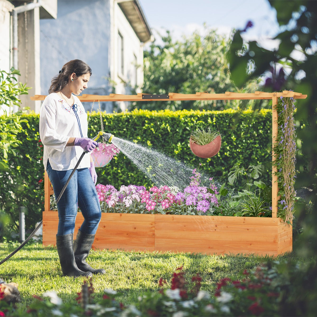 Large outdoor garden bed includes two trellises for vines, climbing plants, lights and hanging baskets